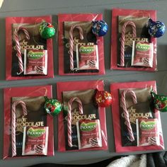 chocolate candies and candy canes are displayed on red paper bags with christmas decorations