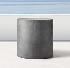 a concrete table sitting on top of a white floor next to the ocean and sky