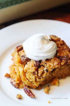 a piece of cake sitting on top of a white plate with whipped cream on top