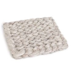 a white knitted blanket sitting on top of a table