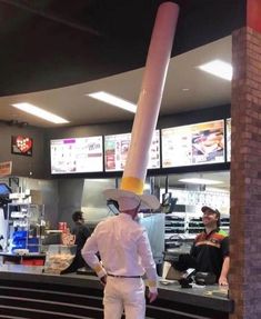 a man standing in front of a counter with a giant object on it's head