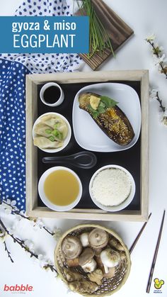 an eggplant dish with mushrooms, rice and sauces in a wooden tray