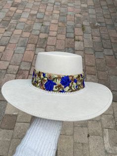 -Made in Guanajuato, Mexico -One size fits most -Stretch band to fit sizes S-L -Manmade -Shipped from Florida -15 in. L -14 in. W -6 in. H -Material felt -4 in. H Crown -hand decorated hat with the perfect eye catching royal blue and shiny jewels to enhance the color and brightness to the hat! White Western Boater Hat With Flat Crown, Custom White Hat Bands For Rodeo, Fitted White Hat Bands For Western-themed Events, Luxury Blue Hat Bands For Rodeo, Custom Blue Wide Brim Hat, Boater Hat, Stretch Band, Perfect Eyes, Stretch Bands