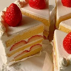 three slices of cake with white frosting and strawberries on top