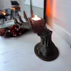 a candle that is on top of a table next to a mirror and some flowers