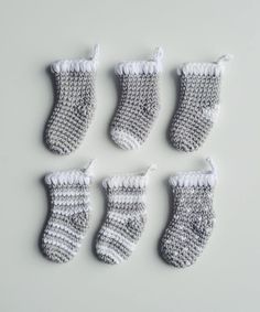 six crocheted christmas stockings hanging from strings