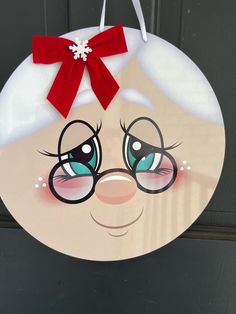 a door hanger with a cartoon character wearing glasses and a red bow on it's head