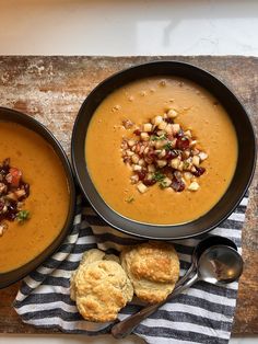 two bowls of soup and biscuits on a table