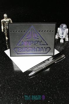 a star wars themed birthday card next to a pen and action figure on a table