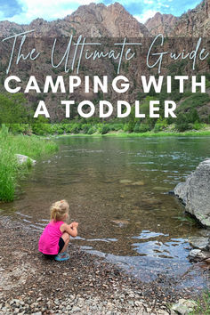 the ultimate guide to camping with a toddler on a rocky river bank in front of mountains