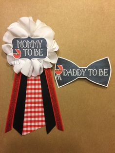 two ribbons with words on them that say mommy to be and daddy to be