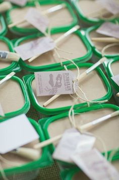 several toothbrushes are on display in green trays with tags and twine