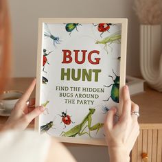 a woman holding up a book with bugs on it