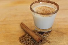 a glass filled with cinnamon sitting on top of a wooden table