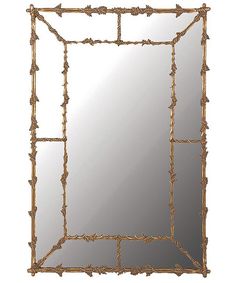 a mirror that is sitting on top of a table and has vines in the frame