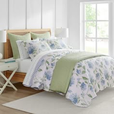 a bedroom with white walls and blue flowers on the bed