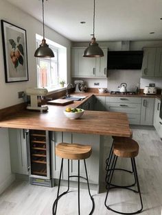 a kitchen island with two stools in front of it