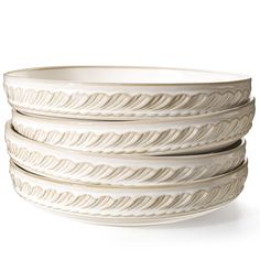 four white bowls stacked on top of each other in the shape of wavy lines and curves