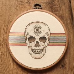 a cross stitch skull on a wooden hoop