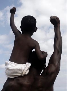 a man holding a child up in the air