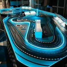 a large model track with cars and lights on it's sides in a dark room