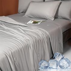 a bed with silver sheets and ice cubes on the floor in front of it