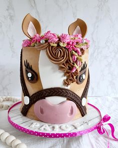 a cake decorated to look like a cow's head with flowers on its face