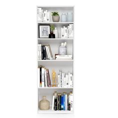 a white book shelf filled with books on top of each other next to a vase