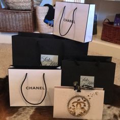 three chanel shopping bags sitting on the floor