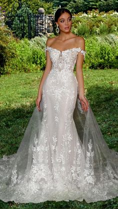 a woman in a wedding dress standing on the grass