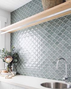 a kitchen with white cabinets and gray tile backsplash