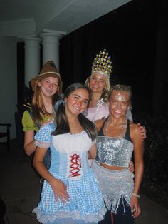 four girls dressed up in costumes posing for the camera