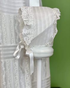 the back of a white chair with lace on it