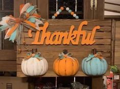 several pumpkins are hanging on a wooden sign