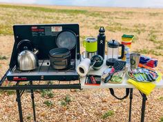 an outdoor cooking station with pots, pans and utensils on the table