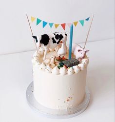 there is a cake that has animals on it and flags in the top tiers