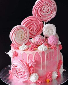 a pink cake with white icing and lots of candies on top