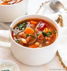 two white bowls filled with soup on top of a table