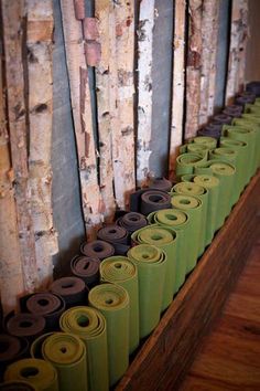 rolls of toilet paper are lined up on the floor in front of wood planks