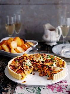 there is a pie that has been cut in half and served on a plate with wine glasses