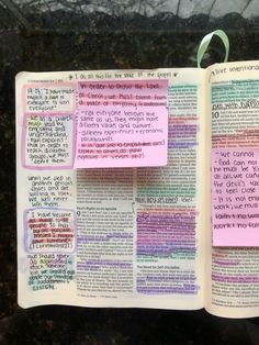 an open bible with sticky notes attached to the pages in pink and green ink, on a granite surface