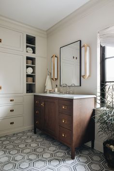 a bathroom with a sink, mirror and cabinets