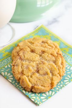 a cookie sitting on top of a green and blue napkin next to a white egg