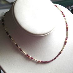 "The deep red gemstones, creamy pearls, and hint of sparkle from the faceted gold seed beads, make for an elegant and delicate choker.  It is 16\" long. I've strung a row of tiny faceted rondelles of garnet in the center of the necklace and then created a pattern  with more garnets, a few little creamy potato pearls and gold plated charlottes. Finishes with a gold plated lobster clasp." Gold Ruby Beaded Necklace With Faceted Beads, Handmade Choker Necklace, Delicate Choker, Handmade Chokers, Creamy Potato, Garnet Necklace, Hammered Sterling Silver, Red Gemstones, Beads Handmade