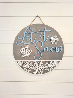 a sign that says let it snow hanging on the wall