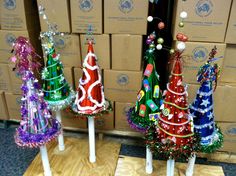 three small christmas trees sitting on top of wooden pallets in front of cardboard boxes