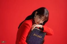 a young woman is holding a book in front of her face