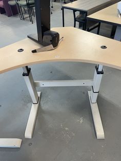 an office desk with a monitor and keyboard on it in a room full of chairs