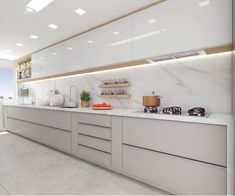 a kitchen with white cabinets and marble counter tops