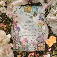 a birthday party book surrounded by flowers